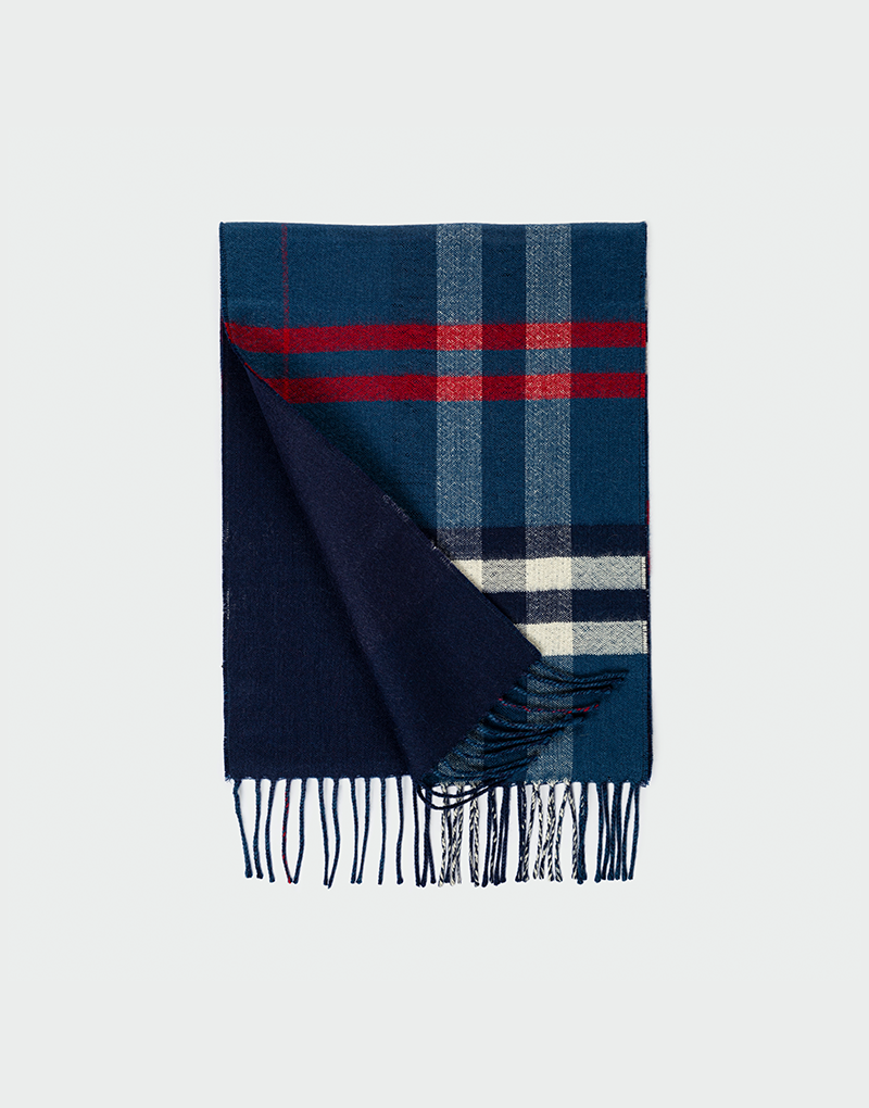 Bufanda a cuadros azul marino rojo y blanco doblada mostrando reverso liso en azul oscuro con flecos delgados
