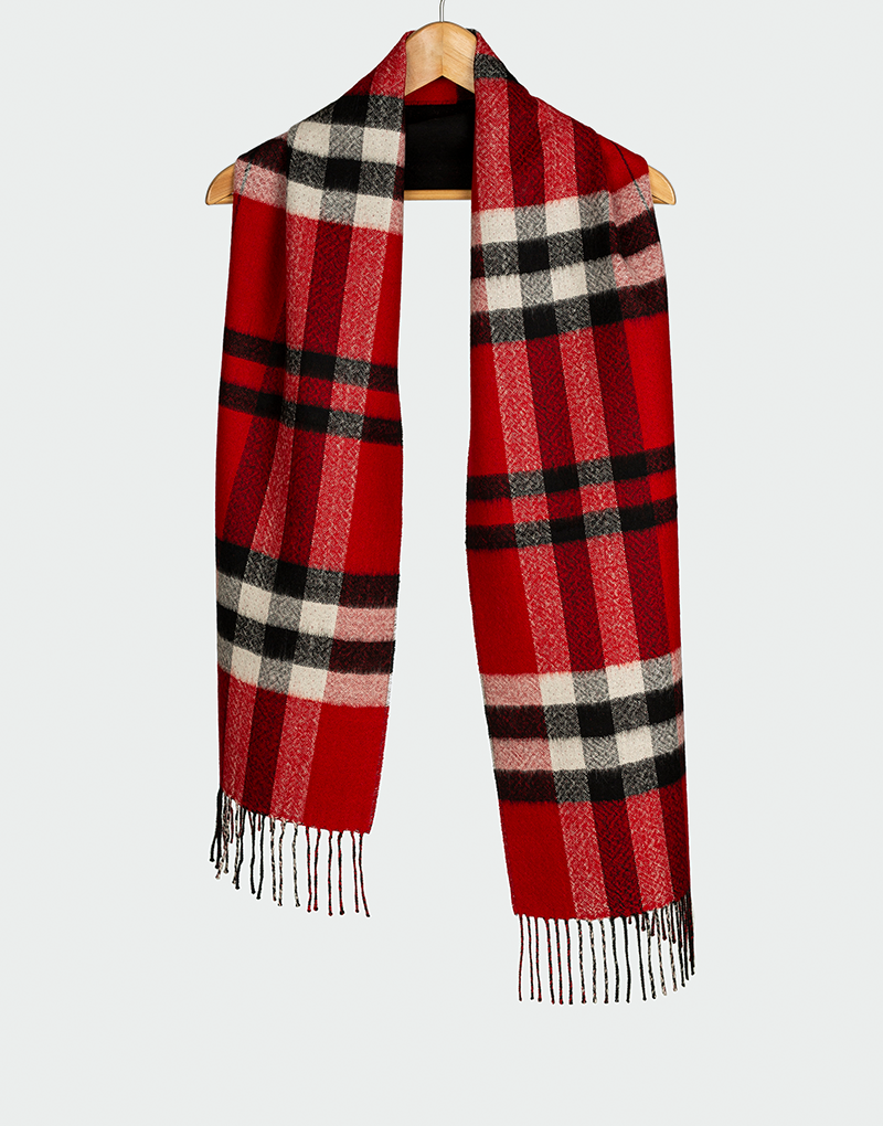 Bufanda a cuadros en tonos rojo negro blanco y rosa con flecos finos colgada en gancho de madera estilo clásico de invierno