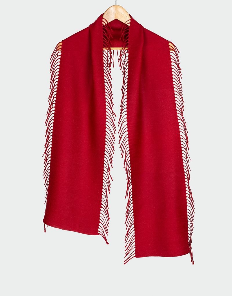 Bufanda roja intensa con flecos laterales largos diseño elegante de caída fluida colgada en gancho de madera