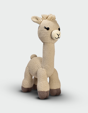 Muñeco alpaca amigurumi hecho a mano en algodón orgánico beige con patas marrón claro y expresión amigable ideal como juguete o decoración infantil sostenible